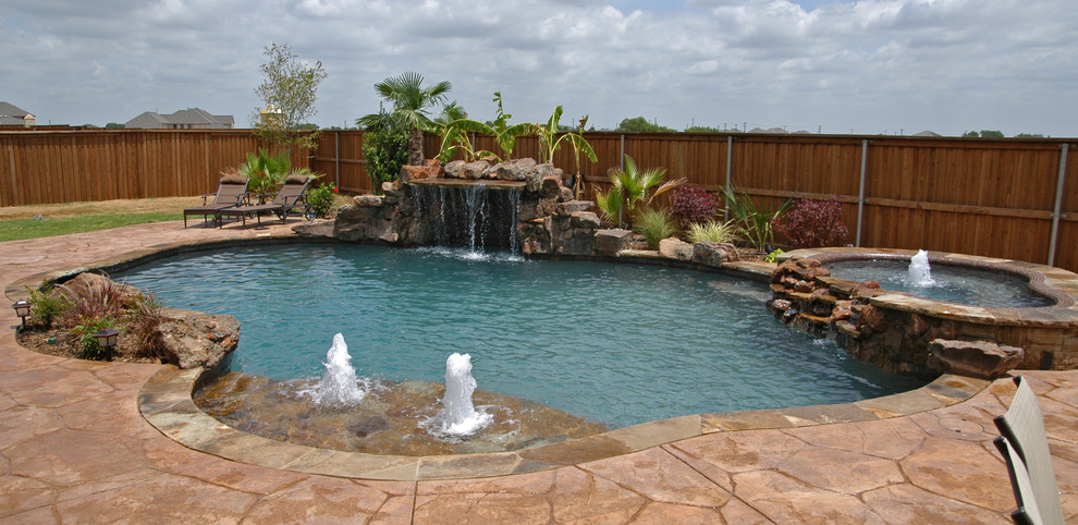 На фото: естественный бассейн среднего размера, произвольной формы на заднем дворе в стиле фьюжн с джакузи и покрытием из каменной брусчатки с