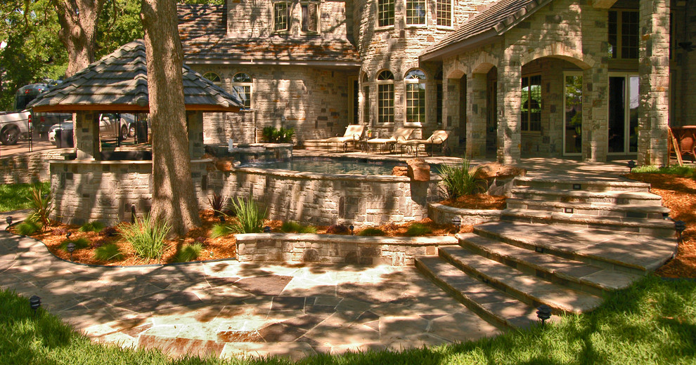 Imagen de piscinas y jacuzzis naturales de estilo americano de tamaño medio a medida en patio trasero con adoquines de piedra natural