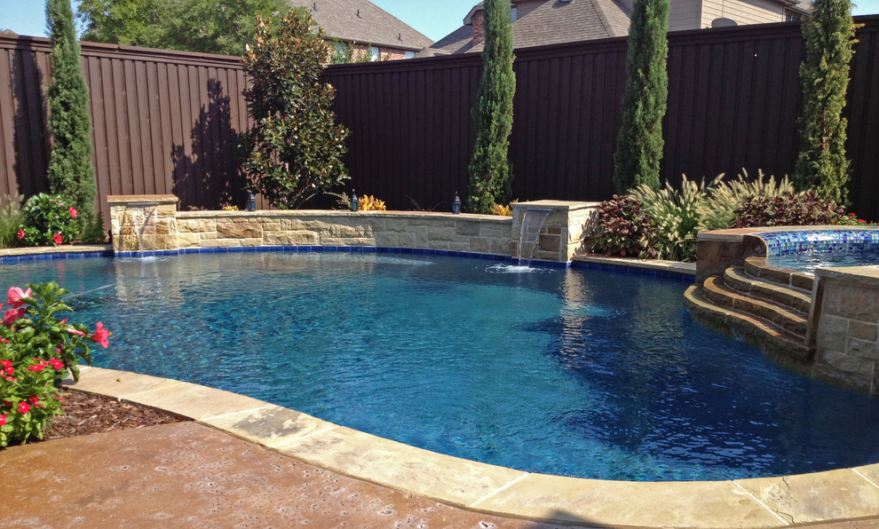 Ejemplo de piscinas y jacuzzis naturales de estilo americano grandes a medida en patio trasero con losas de hormigón