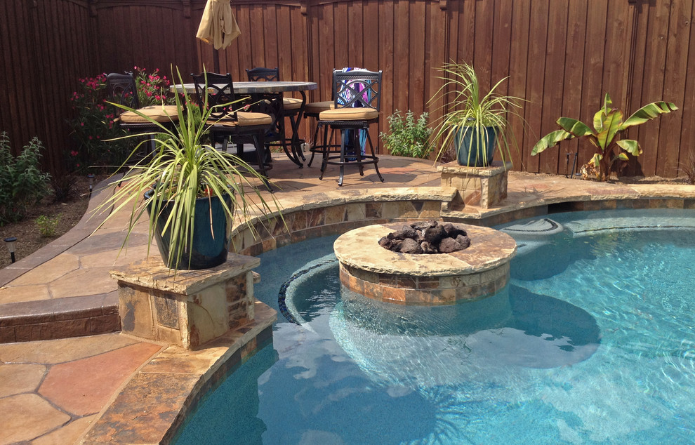 Large back custom shaped natural hot tub in Dallas with natural stone paving.