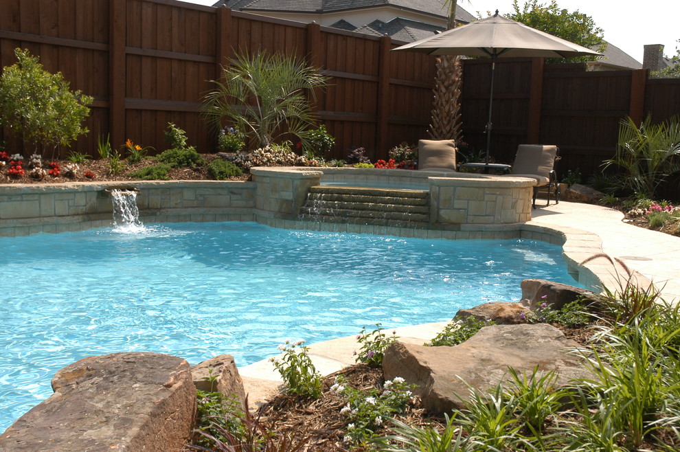 Diseño de piscinas y jacuzzis naturales de estilo americano de tamaño medio a medida en patio trasero con adoquines de piedra natural
