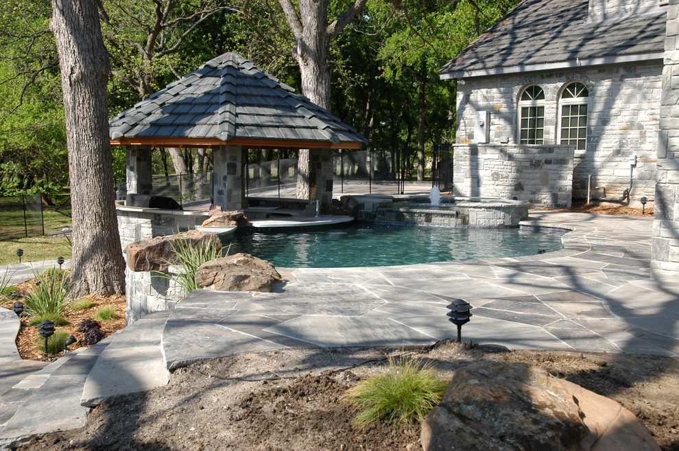 Design ideas for a medium sized back custom shaped natural hot tub in Dallas with natural stone paving.