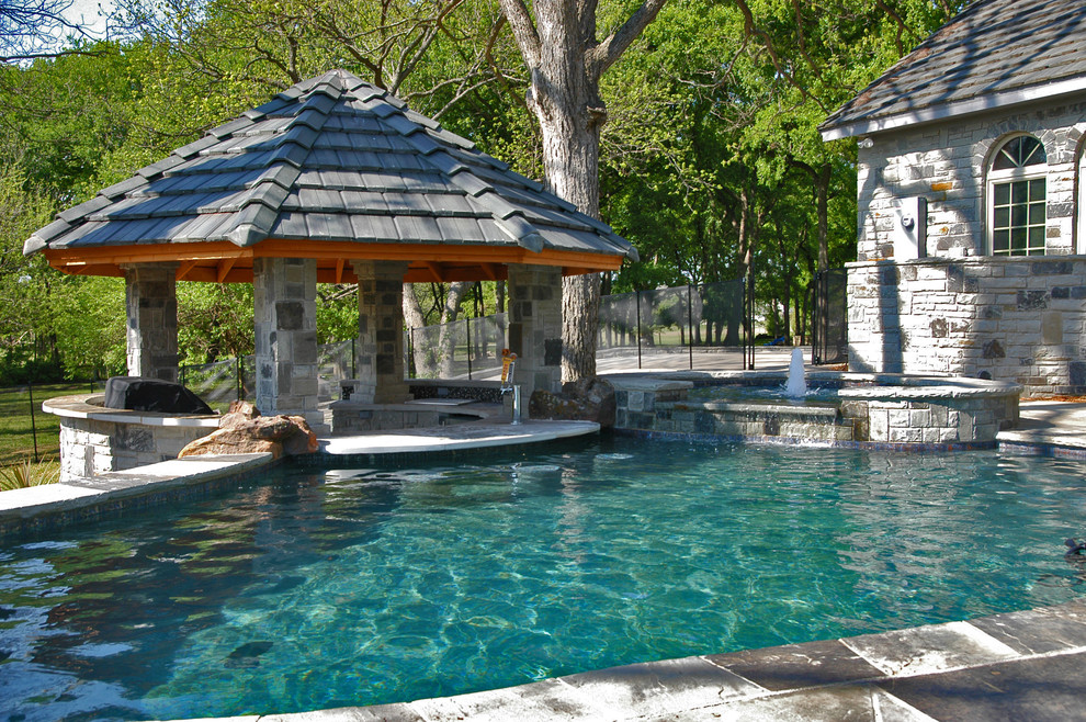 Réalisation d'une piscine naturelle et arrière sud-ouest américain de taille moyenne et sur mesure avec un bain bouillonnant et des pavés en pierre naturelle.