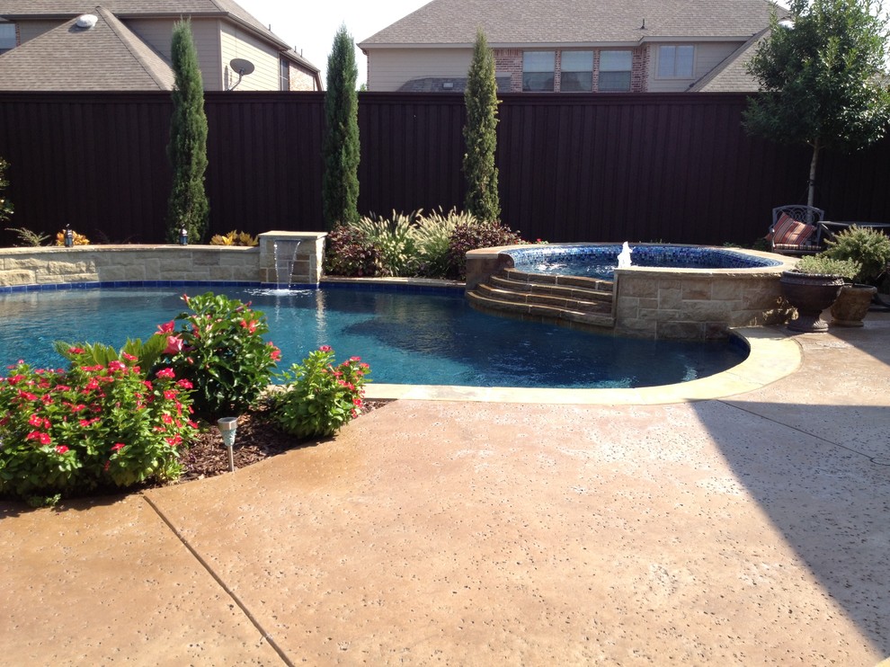 This is an example of a large back custom shaped natural hot tub in Dallas with concrete slabs.