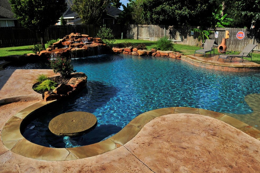 Idee per una grande piscina moderna personalizzata dietro casa con fontane e cemento stampato