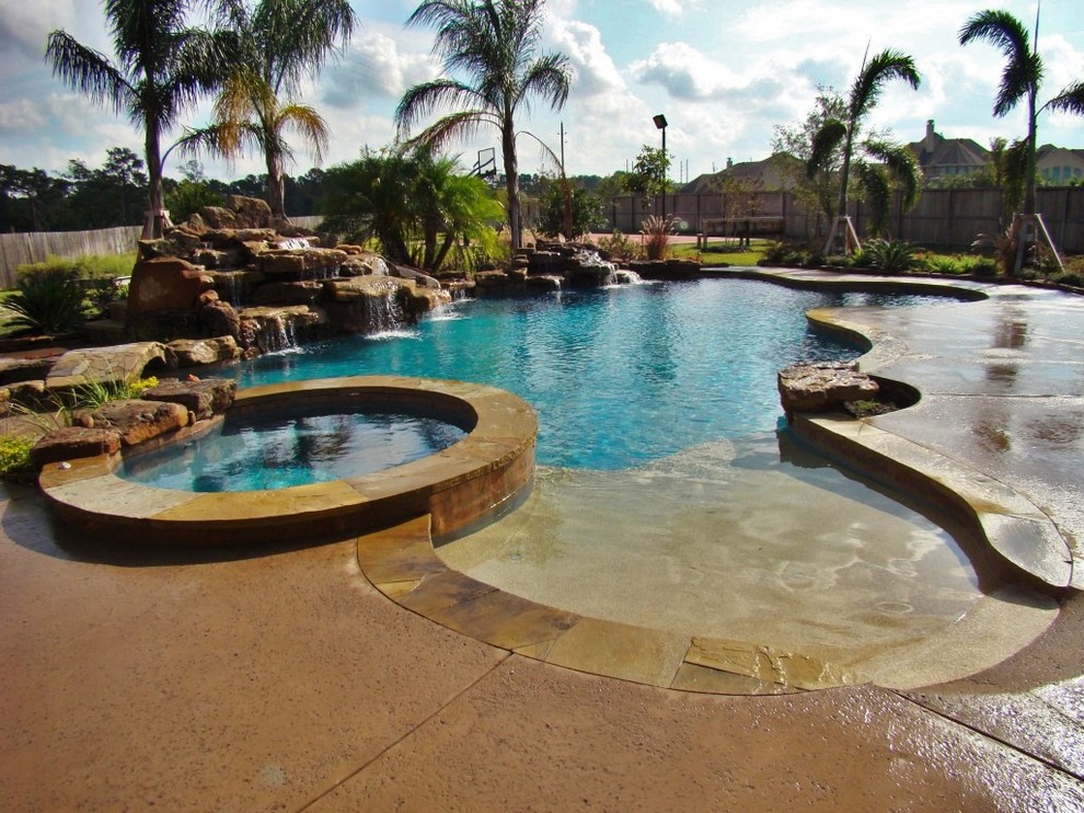 Ejemplo de piscina con fuente minimalista grande a medida en patio trasero con suelo de hormigón estampado