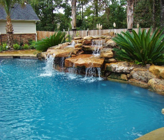 Ispirazione per una grande piscina minimalista personalizzata dietro casa con fontane e cemento stampato