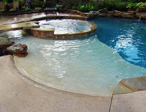 Идея дизайна: большой бассейн произвольной формы на заднем дворе в стиле модернизм с фонтаном и покрытием из декоративного бетона
