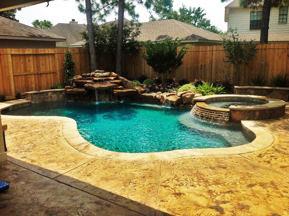 Großer Moderner Pool hinter dem Haus in individueller Form mit Wasserspiel und Stempelbeton in Houston