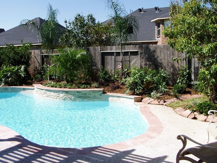 Example of a transitional backyard decomposed granite and custom-shaped pool design in Houston