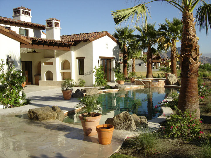 На фото: естественный, прямоугольный бассейн среднего размера на заднем дворе в средиземноморском стиле с мощением клинкерной брусчаткой и джакузи с