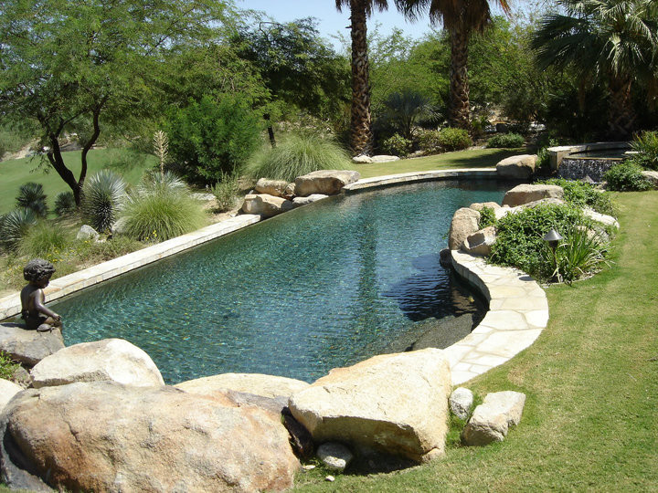 Пример оригинального дизайна: большой естественный бассейн произвольной формы на заднем дворе в средиземноморском стиле с мощением клинкерной брусчаткой и джакузи