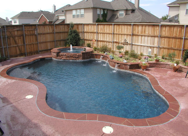 Idee per una piscina chic personalizzata dietro casa e di medie dimensioni con una vasca idromassaggio e cemento stampato