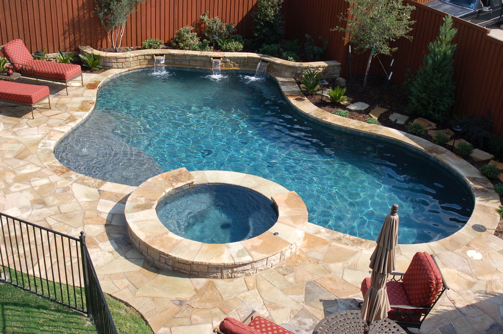 Idee per una piscina classica personalizzata dietro casa e di medie dimensioni con una vasca idromassaggio e pavimentazioni in pietra naturale
