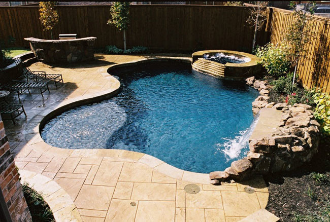 Ispirazione per una piscina chic personalizzata dietro casa e di medie dimensioni con una vasca idromassaggio e pavimentazioni in pietra naturale