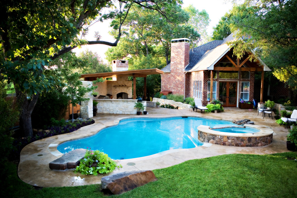 Immagine di una piscina chic personalizzata dietro casa e di medie dimensioni con una vasca idromassaggio e pavimentazioni in cemento