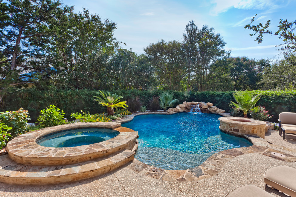 На фото: бассейн среднего размера, произвольной формы на заднем дворе в классическом стиле с джакузи