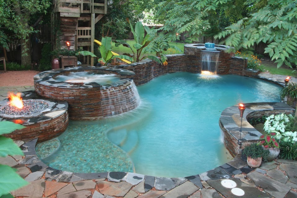 Ispirazione per una piscina chic personalizzata di medie dimensioni e dietro casa con fontane e pavimentazioni in pietra naturale