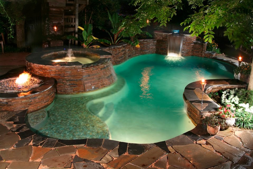 Ispirazione per una piscina tradizionale personalizzata di medie dimensioni e dietro casa con fontane e pavimentazioni in pietra naturale