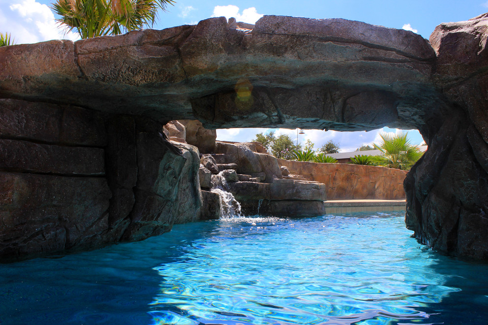 Imagen de piscina con tobogán natural marinera a medida en patio trasero con entablado