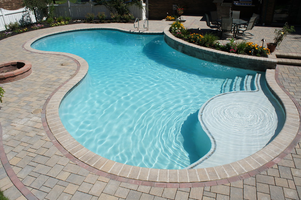 Mid-sized elegant backyard concrete paver and kidney-shaped natural pool fountain photo in Detroit