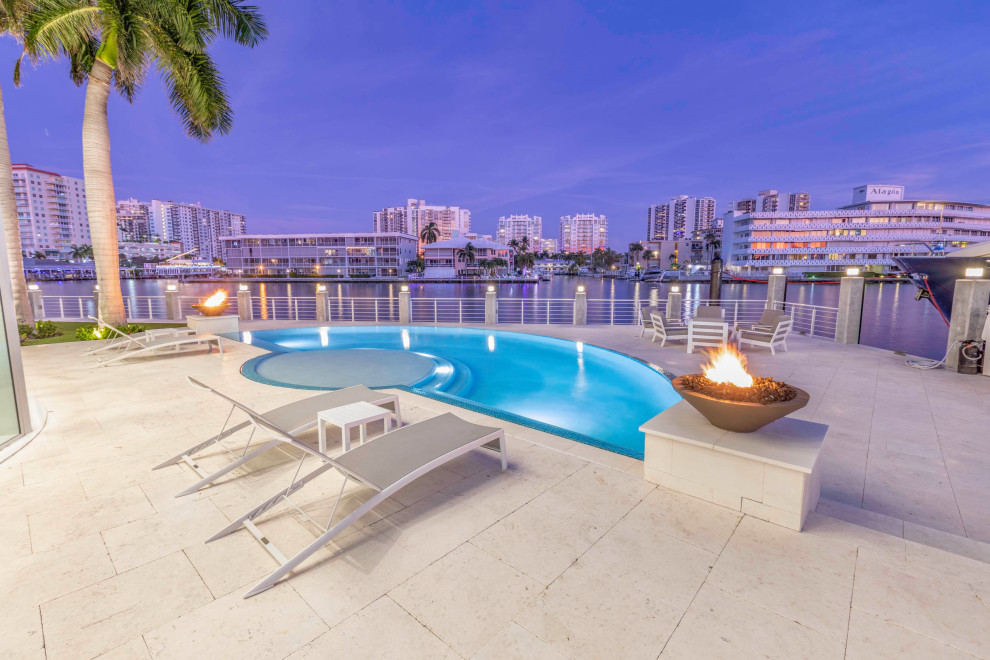 Hot tub - huge modern backyard custom-shaped infinity hot tub idea in Miami