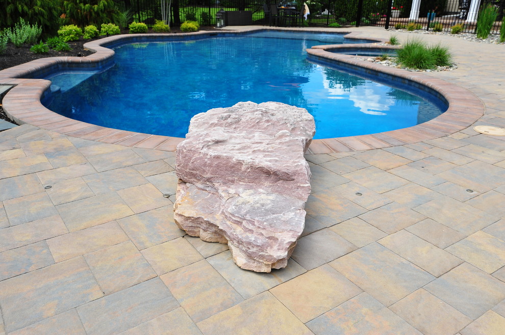 Cette photo montre une piscine arrière chic de taille moyenne et sur mesure avec un point d'eau et des pavés en béton.