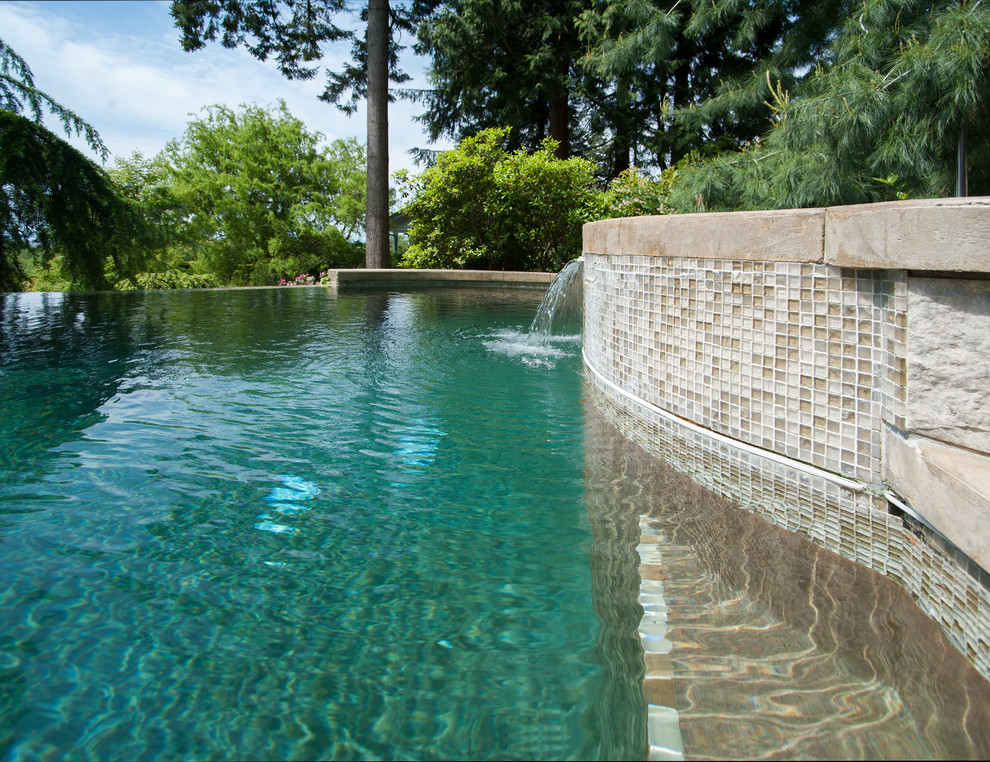 Idee per una piscina a sfioro infinito mediterranea personalizzata dietro casa con una vasca idromassaggio e cemento stampato