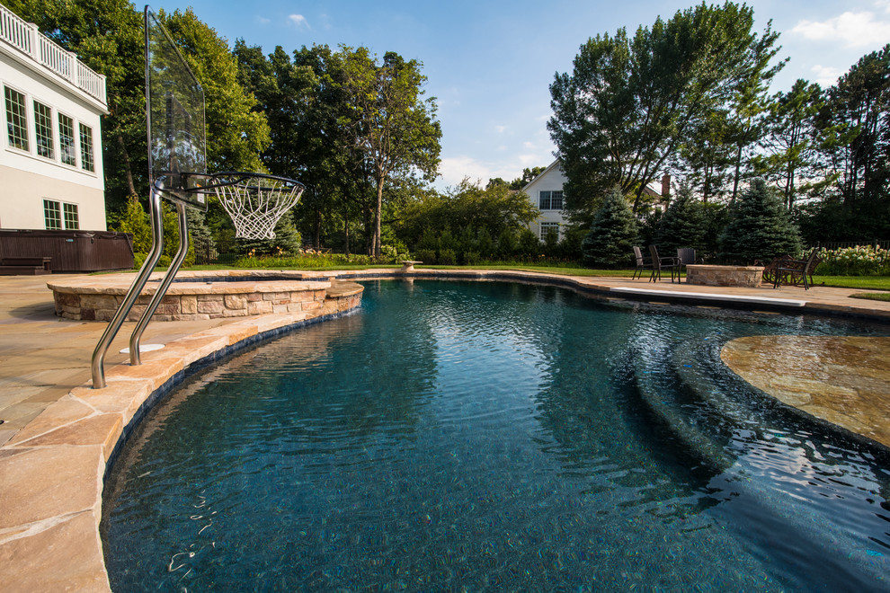 Diseño de piscinas y jacuzzis naturales clásicos de tamaño medio a medida en patio trasero con adoquines de piedra natural