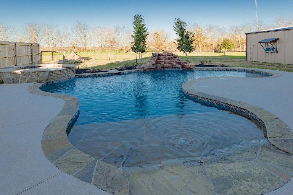 Foto de piscinas y jacuzzis naturales clásicos de tamaño medio tipo riñón en patio trasero con losas de hormigón