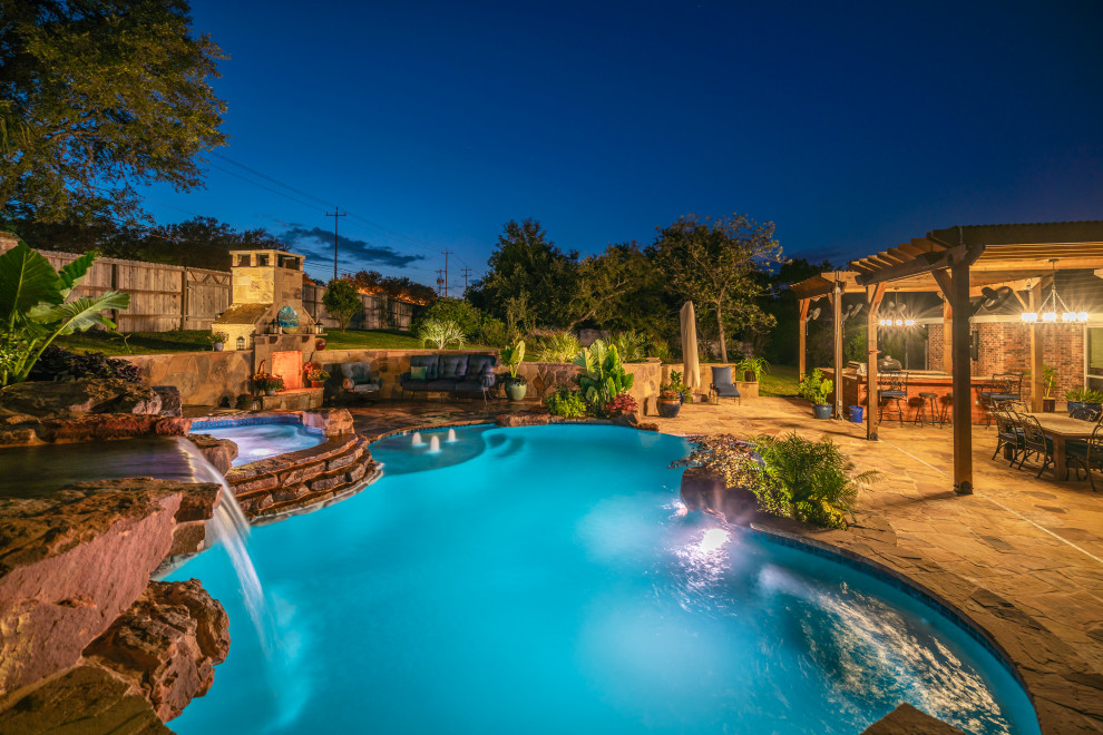 Foto di una grande piscina naturale tropicale personalizzata dietro casa con pedane