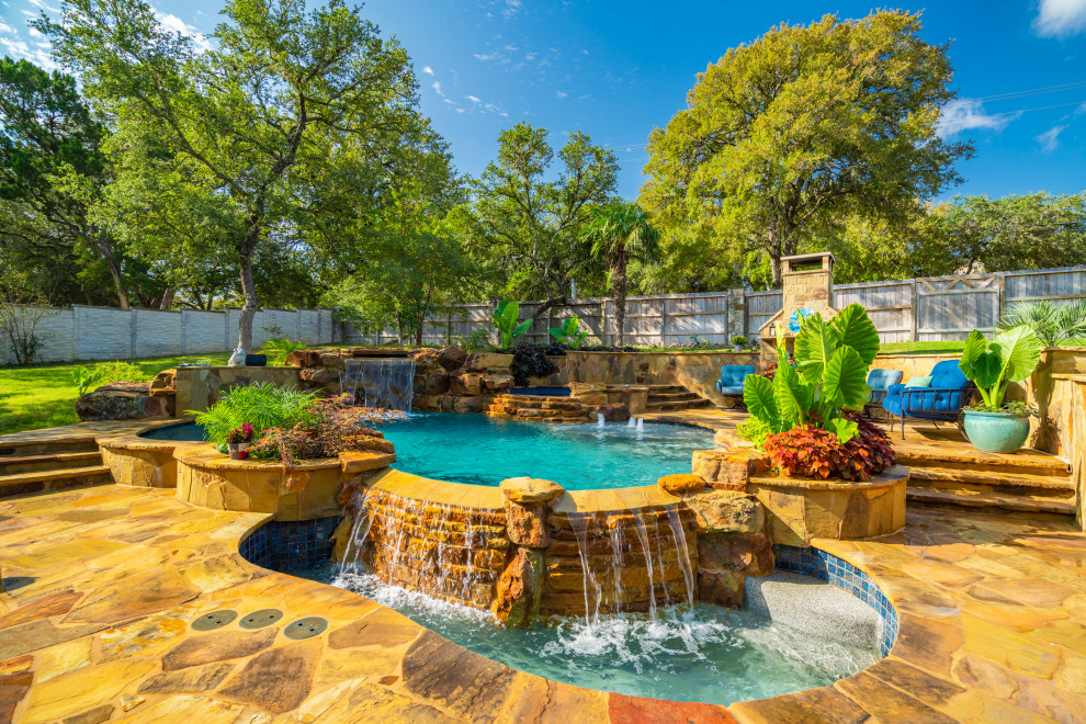 Cette photo montre une grande piscine naturelle et arrière exotique sur mesure avec une terrasse en bois.