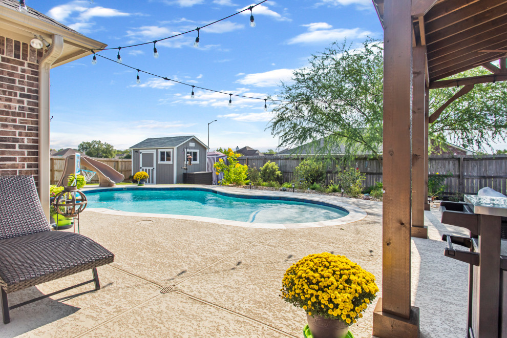Esempio di una piscina naturale personalizzata di medie dimensioni e dietro casa con un acquascivolo e pedane