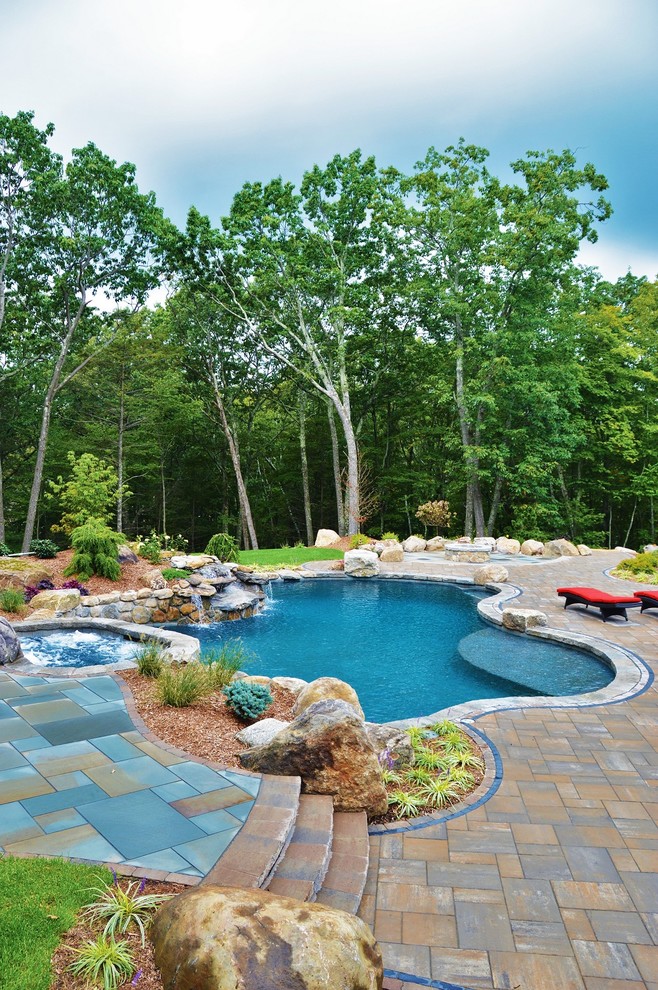 Foto de piscinas y jacuzzis naturales clásicos grandes a medida en patio trasero con adoquines de hormigón