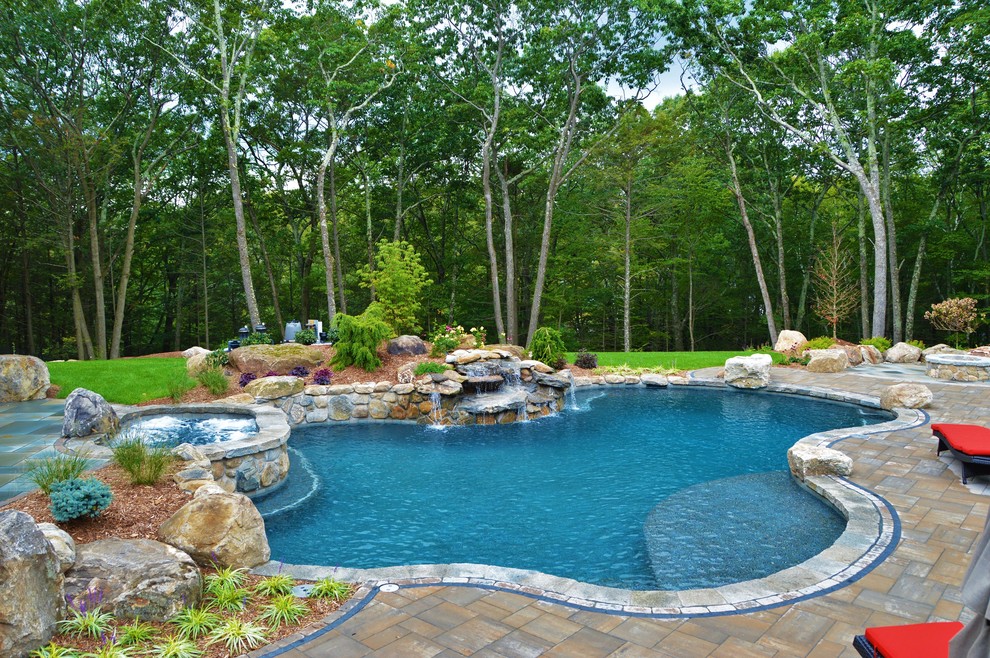 Idee per una grande piscina naturale tradizionale personalizzata dietro casa con una vasca idromassaggio e pavimentazioni in cemento