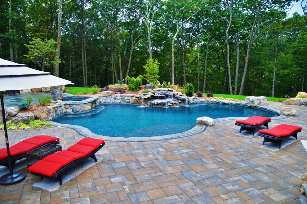 Imagen de piscinas y jacuzzis naturales tradicionales grandes a medida en patio trasero con adoquines de hormigón