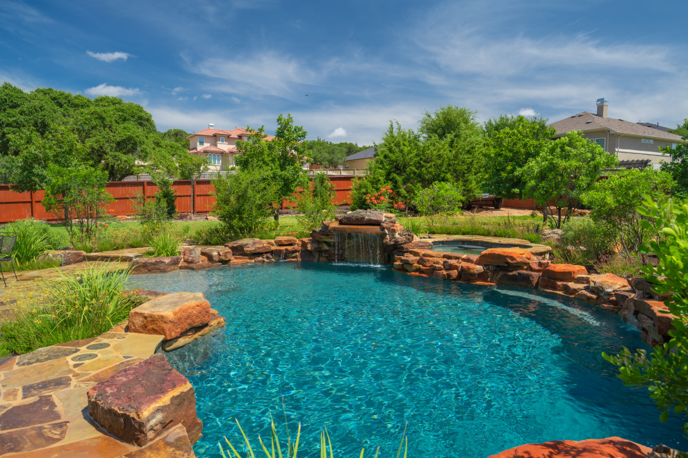 Freeform pool with weeping wall, grotto, and spa in San Antonio, Tx Traditional Pool by