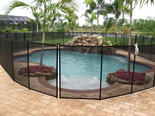 Ispirazione per una piscina naturale tropicale personalizzata di medie dimensioni e dietro casa con pavimentazioni in mattoni