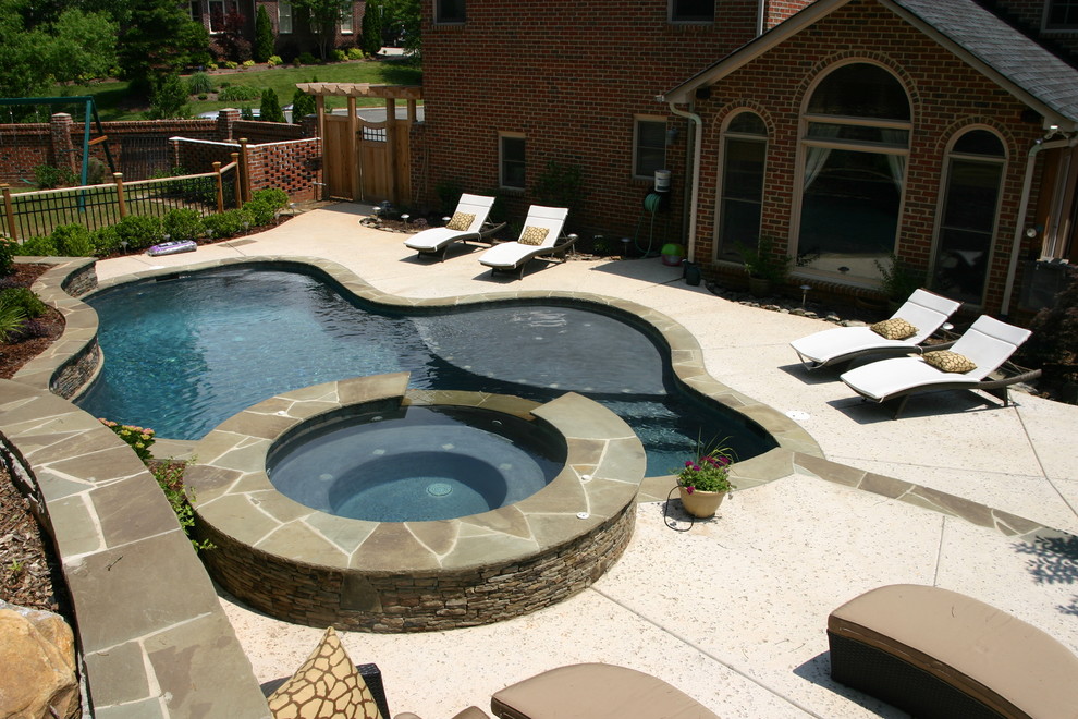 Modelo de piscina con fuente contemporánea de tamaño medio a medida en patio trasero con adoquines de hormigón