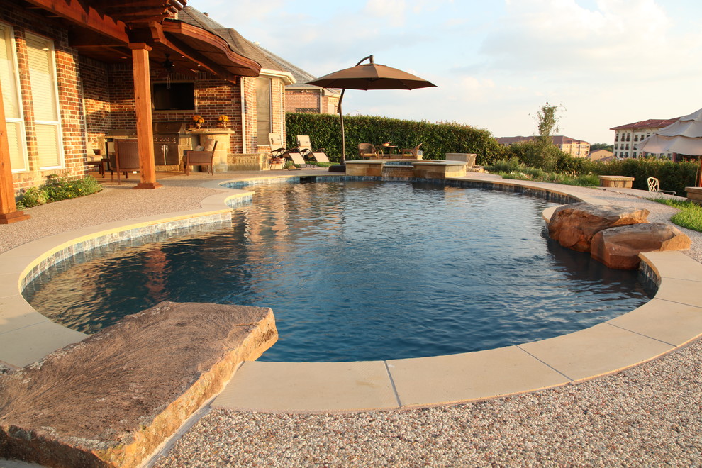 Immagine di una piscina american style personalizzata di medie dimensioni e dietro casa con una vasca idromassaggio e lastre di cemento