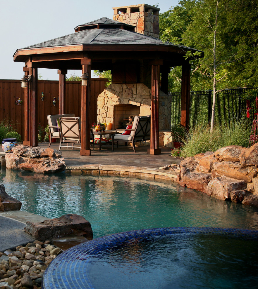 Idee per una piscina naturale stile rurale personalizzata di medie dimensioni e dietro casa con una vasca idromassaggio e lastre di cemento