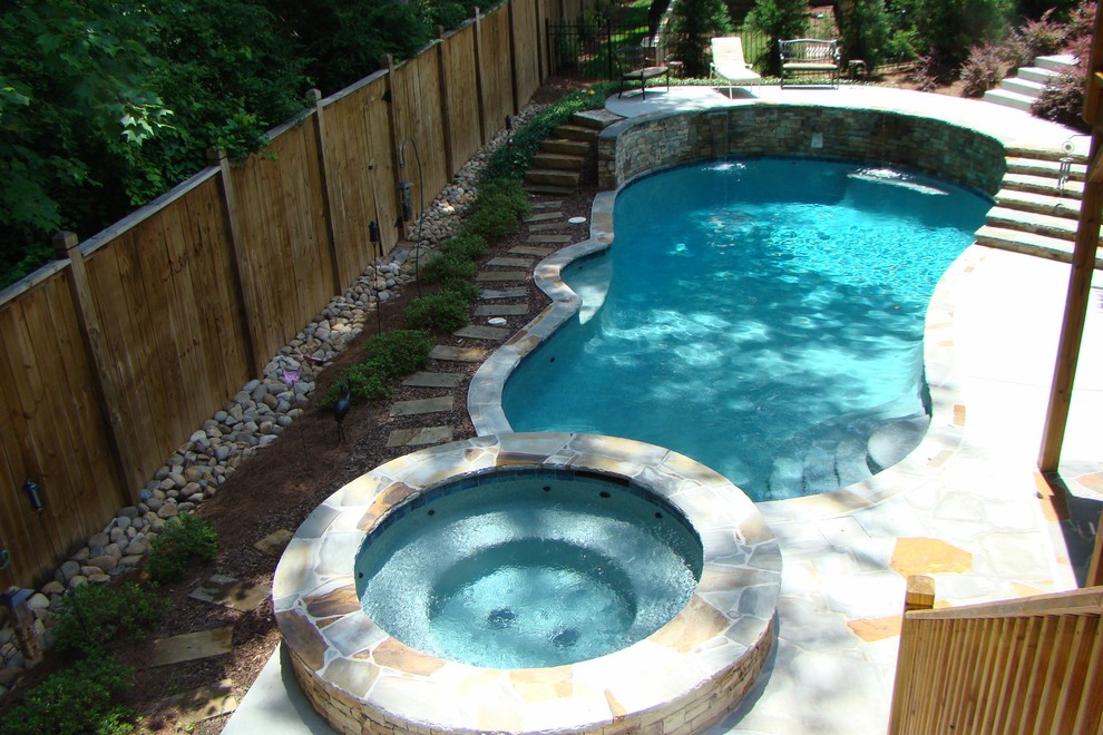 Foto på en stor vintage pool på baksidan av huset, med spabad och naturstensplattor
