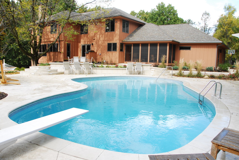 Foto på en mellanstor funkis pool på baksidan av huset, med poolhus och trädäck