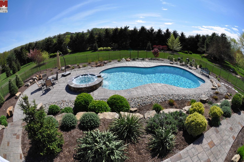 Design ideas for a large contemporary back custom shaped swimming pool in Philadelphia with a water feature.