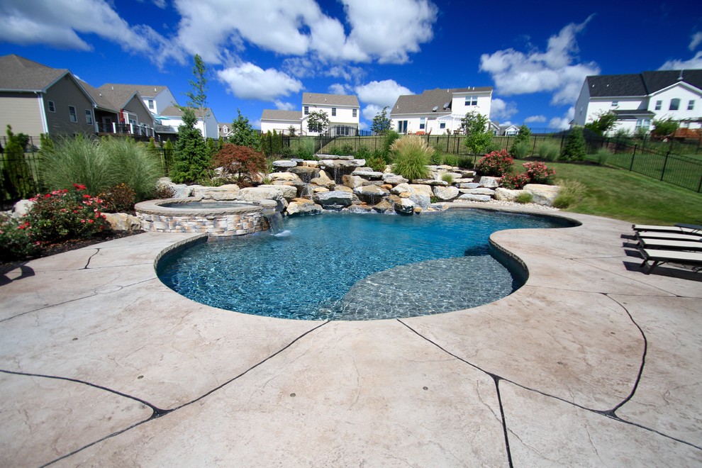Photo of a large contemporary back custom shaped hot tub in Philadelphia with stamped concrete.
