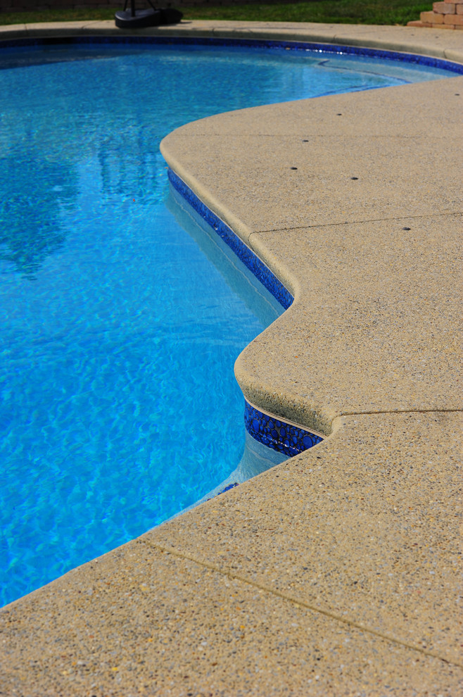 Immagine di una grande piscina contemporanea personalizzata dietro casa con lastre di cemento