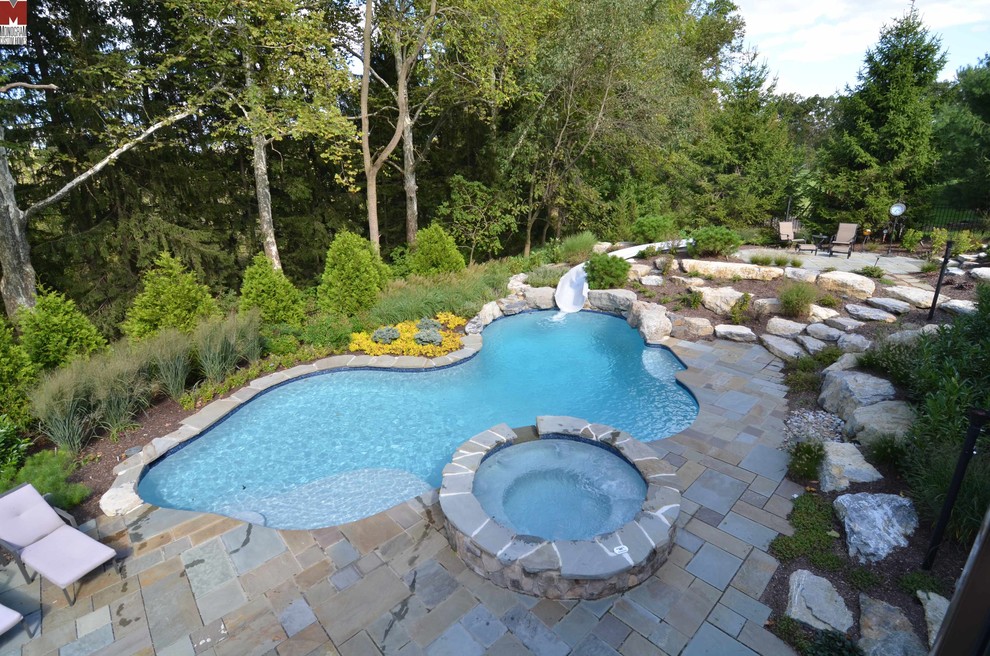 Foto di una piscina contemporanea personalizzata di medie dimensioni e dietro casa con un acquascivolo