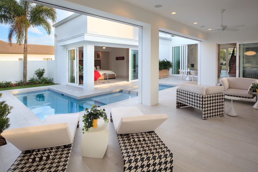 Стильный дизайн: угловой бассейн на внутреннем дворе в стиле модернизм с покрытием из плитки и фонтаном - последний тренд