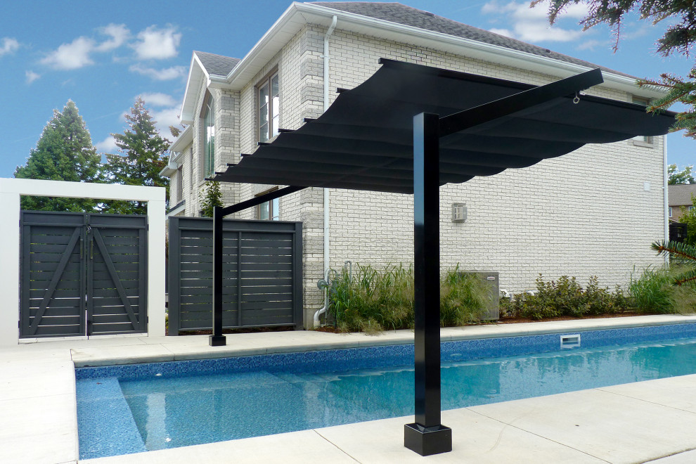 Diseño de piscina alargada moderna grande rectangular en patio lateral con suelo de baldosas