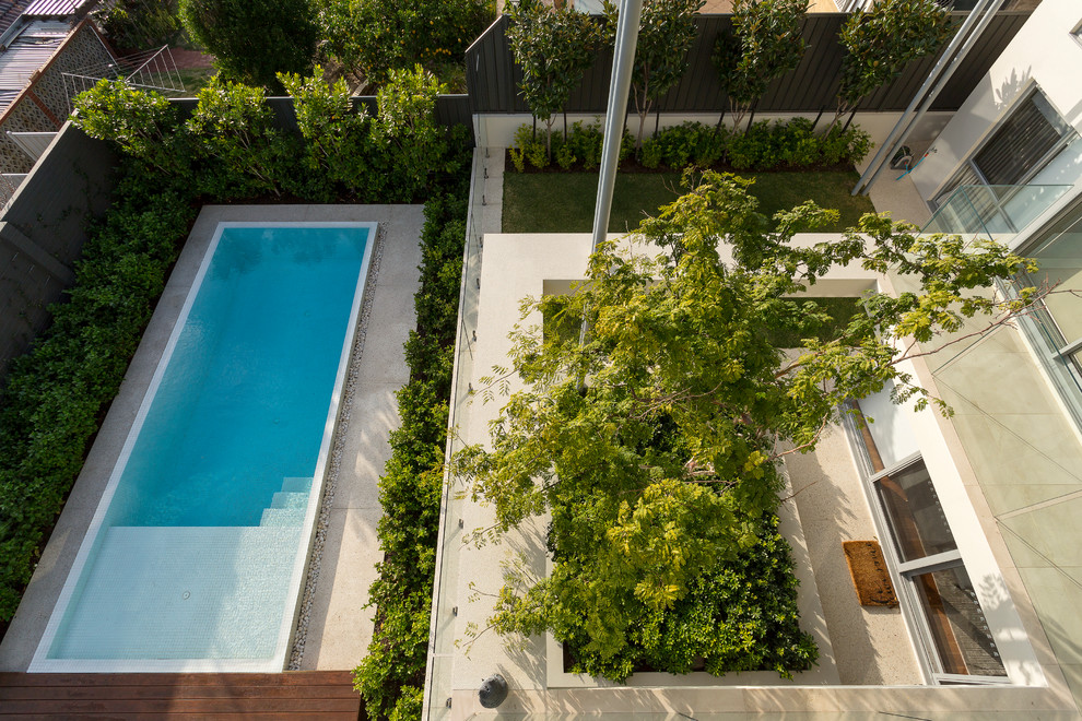 Immagine di una grande piscina a sfioro infinito contemporanea rettangolare dietro casa con pedane